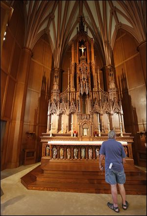 Fred Folger of Toledo stands in front of the altar  during a tour of St. Francis de Sales Chapel downtown. 