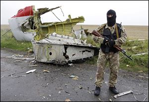 A pro-Russia fighter stands guard at the site of the crashed Malaysia Airlines plane.