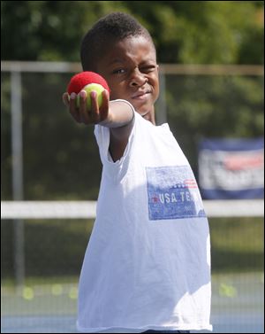 Michael Woods, 7, aims the ball for a serve during Ethel Parker's Tennis Camp.