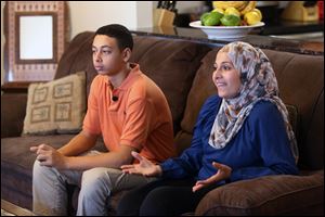 Tariq Abu Khdeir, 15, left, sits with his mother Suha Khdeir during interview in their home Sunday in Tampa.
