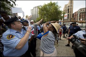 Police try to stop a woman wielding a cane from hitting another woman, not pictured, who was supporting Israel in its war with Hamas members in the Gaza Strip, during a rally at John F. Kennedy Plaza, also known as Love Park, in Philadelphia on Wednesday.