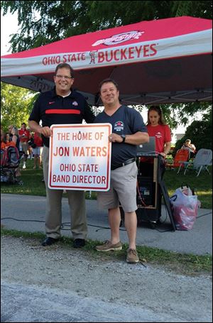 Jon Waters, left, and Elmore mayor Matt Damschroder, holds the sign during the village’s official dedication of the ‘‍Home of Jon Waters’ marker.