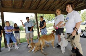 Tina Yoppolo, right, president of Toledo Unleashed, and Sue Joseph, left, treasurer of the group, speak to neighborhood residents about the city’s dog park.
