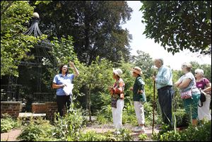 Staci Stasiak, left, explains the variety of plants and flowers in the garden to visitors.