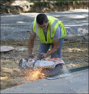 Todd  Larson cuts a sign's pole during construction of Gallitin Road in Ottawa Hills. Ottawa Hills is going to the voters in November with a request for an additional 3.9-mill continuing levy, the proceeds of which would be used for street, bridge, and sidewalk improvements.