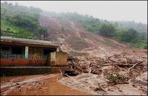 Mud and slush surround a building after a mudslide in Malin village, in the western Indian state of Maharashtra, Wednesday.