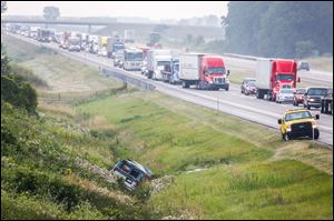 A van lies at rest in a ditch as traffic is backed up on the Ohio Turnpike near Archbold following an accident.