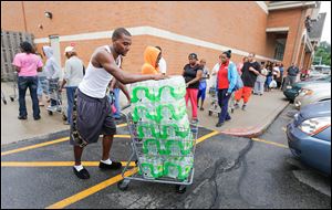 Donald White hauls off water he purchased at Walgreens on Monroe Street on Saturday.