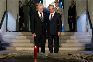 France's President Francois Hollande, right, stands with German President Joachim Gauck, left, as they pay respect in the crypt of the the National Monument of Hartmannswillerkop, in Wattwiller today in eastern France.