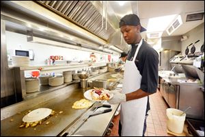 Chef T.J. Harvey, at The Original Pancake House, puts the finishing touches on crepes while cooking for the lunch crowd Monday.