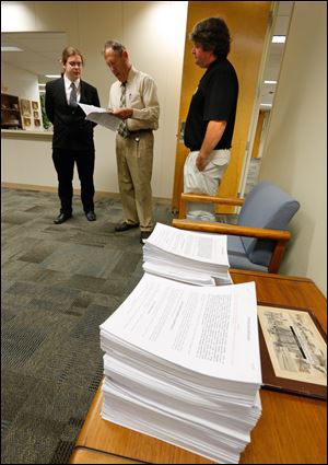 Sean Nestor, left, and Ken Sharp right, of Northwest Ohio NORML, present petitions for an ordinance to decriminalize marijuana to Toledo Clerk of Council Jerry Dendinger today at One Government Center.