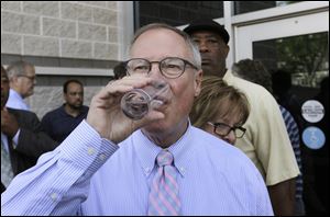 Toledo Mayor D. Michael Collins drinks a glass of tap water after a news conference Monday after lifting the 'do not drink' advisory on city water.