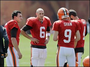 Cleveland Browns quarterbacks Johnny Manziel, left, Brian Hoyer (6), Connor Shaw (9) and Tyler Thigpen talk during practice at NFL football training camp in Berea, Ohio today.