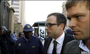 Oscar Pistorius, second from right, accompanied by a relative arrives at the high court in Pretoria, South Africa, today.