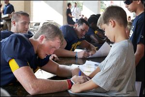 University of Toledo tight end Grant Sherman signs the T-shirt of 8-year-old Leyton Marsh during Fan Appreciation Day on Saturday at the Glass Bowl. 