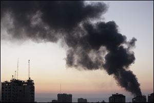 Smoke from a fire on a cleaning materials factory caused by an Israeli strike rises over Gaza City on Sunday.