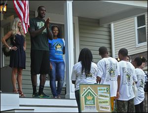 Rehab Addict TV show host, Nicole Curtis, left,  Cleveland Cavalier LeBron James, center, and his wife, Savannah, right, speak during the final reveal to neighbors, friends and people involved in the renovation project of the house in West Hill.