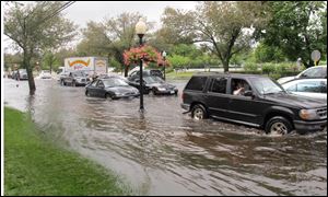 Vehicles attempt to maneuver down a flooded Montauk Highway in Babylon,  N.Y., Wednesday. The National Weather Service says parts of Long Island experienced record-setting rainfall in the past 24 hours. 