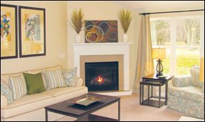 A vaulted ceiling and a gas fireplace with a granite surround make this great room an inviting space.