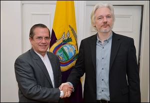 Ecuador's Foreign Minister Ricardo Patino, left, shakes hands with WikiLeaks founder Julian Assange after a news conference inside the Ecuadorian Embassy in London today where Assange confirmed he 