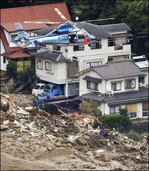 A survivor is lifted by a rescue helicopter from an area devastated by a massive landslide in western Japan.