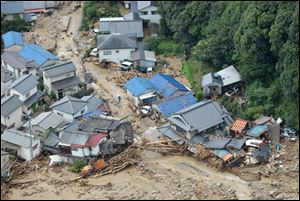 Houses are heavily damaged after a massive landslide swept through residential areas in Hiroshima, western Japan, today.