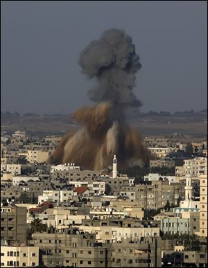 Smoke and debris rise after an Israeli strike hit Gaza City in the northern Gaza Strip, Tuesday. The Israeli military said it carried out a series of airstrikes Tuesday across the Gaza Strip in response to renewed rocket fire.