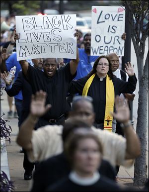 Protesters march to the Buzz Westfall Justice Center Wednesday in Clayton, Mo