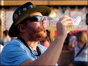 Cory Allarding of Oregon enjoys a beer at the 49th annual German-American Festival at Oak Shade Grove in Oregon. The festival, which opened Friday, continues through Sunday.