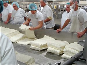 A tour group, including Bob Staller, manager of the Anderson's Market in Sylvania, second from left, learn the cheese making process during a tour of Henning's cheese factory Aug. 13 in Kiel, Wis.