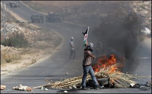 Palestinian protesters face Israeli soldiers during clashes, following a protest against the Israeli military action in Gaza.