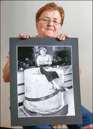 Evelyn Sandrock, 79, holds the now famous Blade photo of her at Tiedke’s Department Store in 1955. She worked in the store’s advertising office.