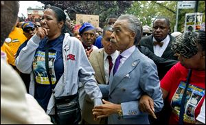Esaw Garner, left, becomes emotional as she arrives at the spot where her husband, Eric Garner, died, at the start of a march and rally today in the Staten Island borough of New York.