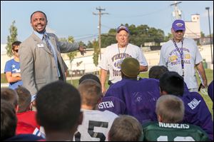 TPS Superintendent Romules Durant, left, shares words of acclimation and congratulation for co-head coaches Harold Keaton, center, and Dave Wendt in a surprise award ceremony following practice.