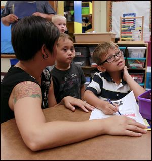 Kristin Hearns and sons Cohen, 3, and Parker, 5, attend an open house at Jackman Road Elementary School in Temperance. Parker was getting familiar with the workings of his kindergarten class.