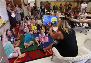 Kindergarten teacher Erica Lehr reads ‘‍The Kissing Hand’ at Jackman Road Elementary School in Temperance. Two schools, Smith Road and Temperance Road, were closed in cost-cutting moves.