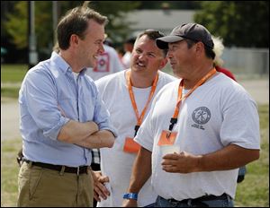 Ed FitzGerald, Democratic candidate for Ohio governor, talks with John Mickey, political director of the Greater Northwest Ohio AFL-CIO, center, and Chris Monaghan, president of the Northwest Ohio AFL-CIO, right, during the Northwest Ohio Laborfest.