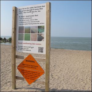 Sign warns against swimming and wading at Maumee Bay State park because of the toxic algae bloom.