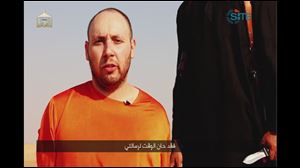 This image from video posted on the Internet by Islamic State militants purports to show U.S. journalist Steven Sotloff before he was beheaded. The Arabic text at the bottom of the frame translates to 