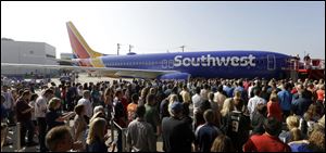 Southwest Airlines employees crowd around a newly unveiled plane paint color scheme during an event Monday at Love Field in Dallas. 