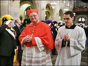 Cardinal Timothy Dolan of New York smiles as he is led into Our Lady, Queen of the Most Holy Rosary Cathedral for the installation ceremony.