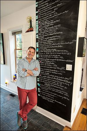 Gregg Dodd stands with his list of 2014 New Year’s resolutions. Mr. Dodd woke up 365 days ago feeling inspired so he scrawled 52 items on a board with the goal of checking off an average of one each week.