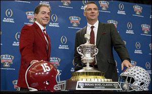 Alabama coach Nick Saban, left, and Ohio State coach Urban Meyer pose with the Sugar Bowl Classic trophy during a press conference in 2014.