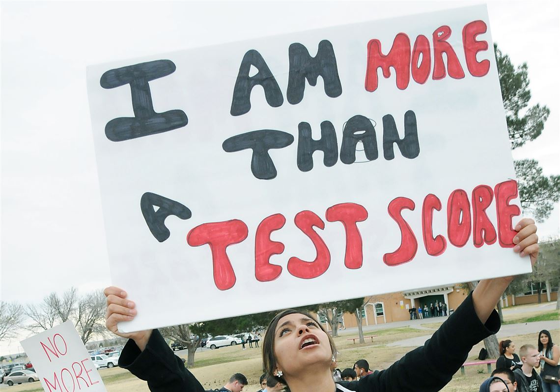 Mayfield High School junior Laura Cruz, 18, looks up at the sign she is holding on March 2, 2015, during a student-organized walkout to protest the PARCC exams in Las Cruces, N.M.