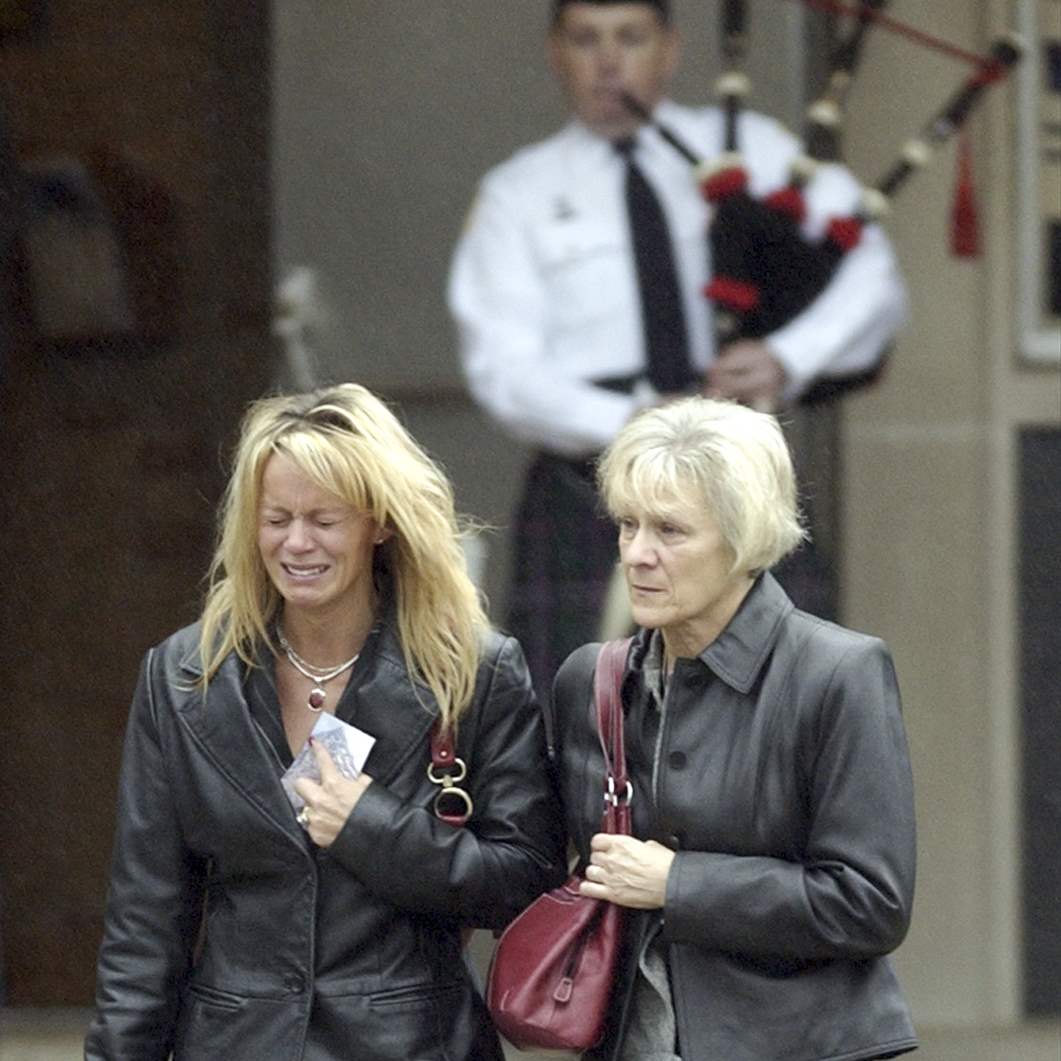 REG-wopler14p-C-jpgMourners-leave-the-funeral-of-Staff-S