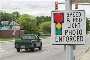 A signs warns motorists of an approaching traffic-enforcement camera near the intersection of Cherry Street and East Delaware Avenue in Toledo.