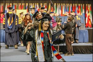 Nicole Harris of Toledo celebrates Sunday after receiving her diploma, a B.A. in Criminal Justice.