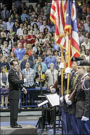 Jason Strumbo of UT’s music department conducts an ensemble. At right is the UT Pershing Rifles color guard.