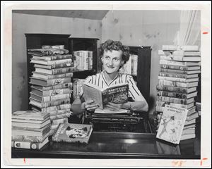 A Toledo Times photo of Mildred Wirt at her desk surrounded by her works on in August, 1949.
