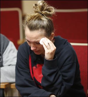 A woman who only identified her self as the mother of victim Jeremy Linhart's child reacts to the news conference.